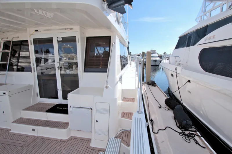 Slide: The Image of 1999 West Bay 58 Sonship yacht docked at marina, showcasing exterior and deck area. - 37