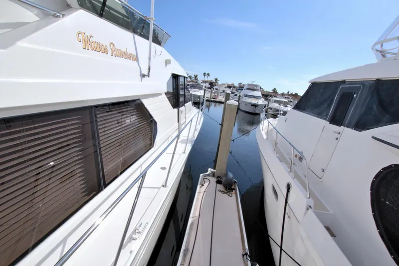 Slide: The Image of Two yachts docked closely at a marina, featuring a 1999 West Bay 58 Sonship. - 38
