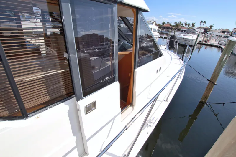 Slide: The Image of 1999 West Bay 58 Sonship yacht docked at marina, showcasing sleek design and spacious deck. - 39