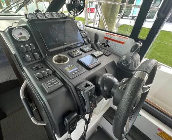 Slide: The Image of Control panel of a 2020 Jeanneau NC 37 boat with steering wheel and navigation equipment. - 11