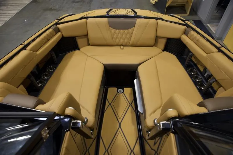Slide: The Image of Luxurious interior of 2025 Malibu M242 boat with tan leather seating and cup holders. - 17