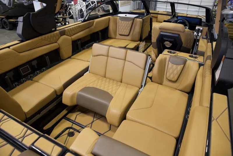 Slide: The Image of 2025 Malibu M242 boat interior with luxurious tan leather seating and modern design features. - 21
