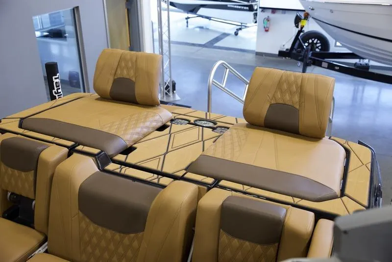 Slide: The Image of 2025 Malibu M242 boat interior with luxurious tan seating and diamond stitching. - 32