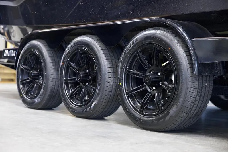Slide: The Image of Triple axle trailer with black wheels for 2025 Malibu M242 boat. - 5