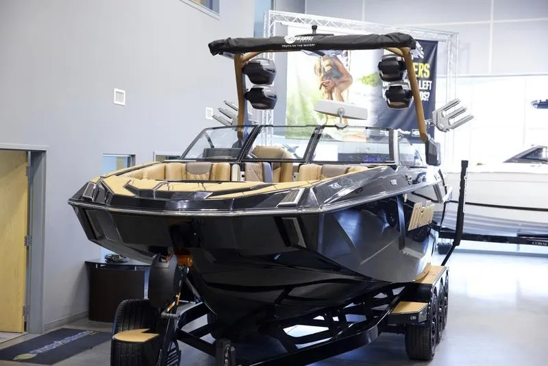 Slide: The Image of 2025 Malibu M242 boat displayed indoors on a trailer, featuring sleek design and modern amenities. - 8