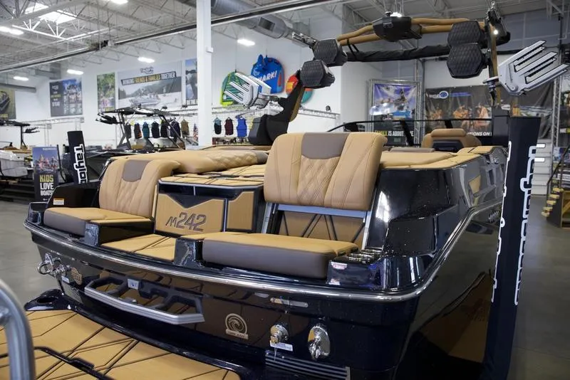 Slide: The Image of 2025 Malibu M242 boat with tan seating in a showroom. - 9