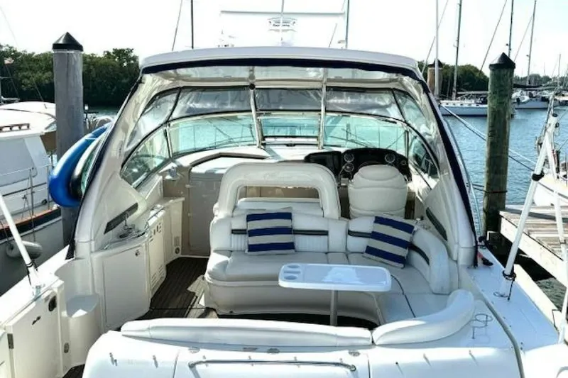 Slide: The Image of 2003 Sea Ray 420 Sundancer yacht interior with striped cushions, docked by the water. - 11