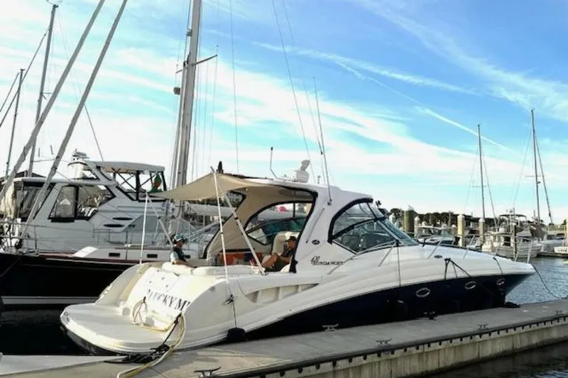Slide: The Image of 2003 Sea Ray 420 Sundancer yacht docked at marina under clear blue sky. - 2