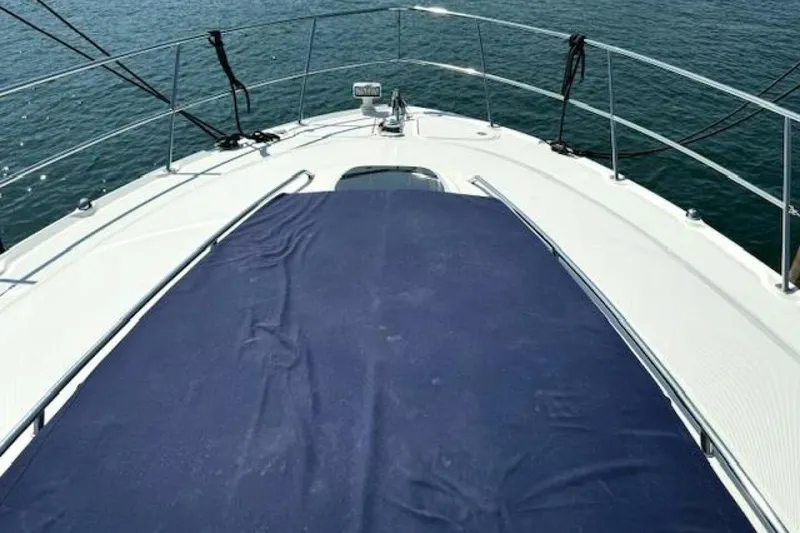 Slide: The Image of Bow of 2003 Sea Ray 420 Sundancer yacht with anchor and railing on calm water. - 29