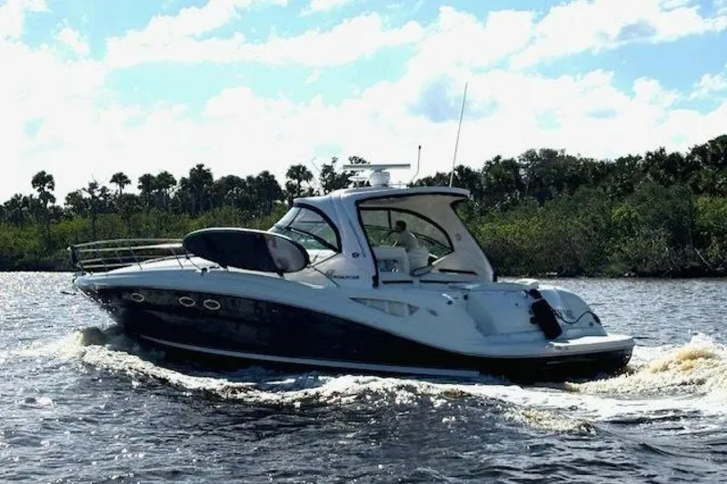 Slide: The Image of 2003 Sea Ray 420 Sundancer cruising on a sunny day, surrounded by lush greenery. - 3