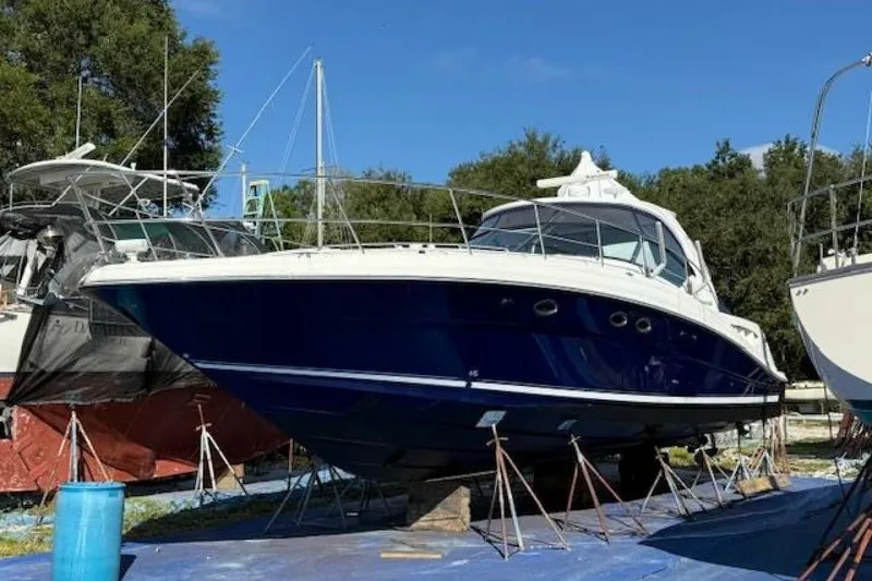 Slide: The Image of 2003 Sea Ray 420 Sundancer boat on stands, showing propellers and hull. - 50