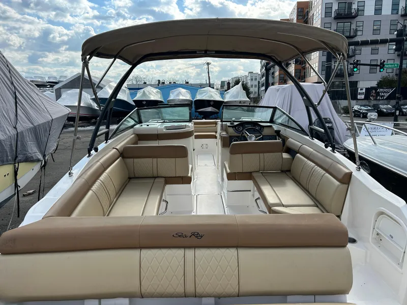 Slide: The Image of 2015 Sea Ray 270 Sundeck boat with spacious seating and canopy, docked outdoors. - 2