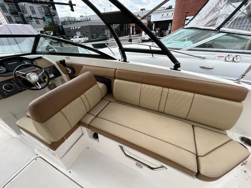 Slide: The Image of 2015 Sea Ray 270 Sundeck interior with beige seating and steering wheel. - 4