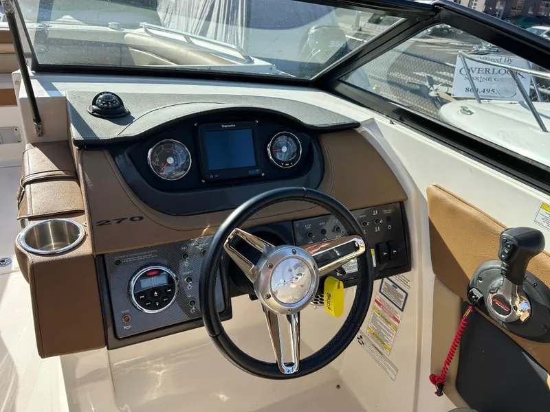 Slide: The Image of 2015 Sea Ray 270 Sundeck dashboard with steering wheel and control panel. - 6