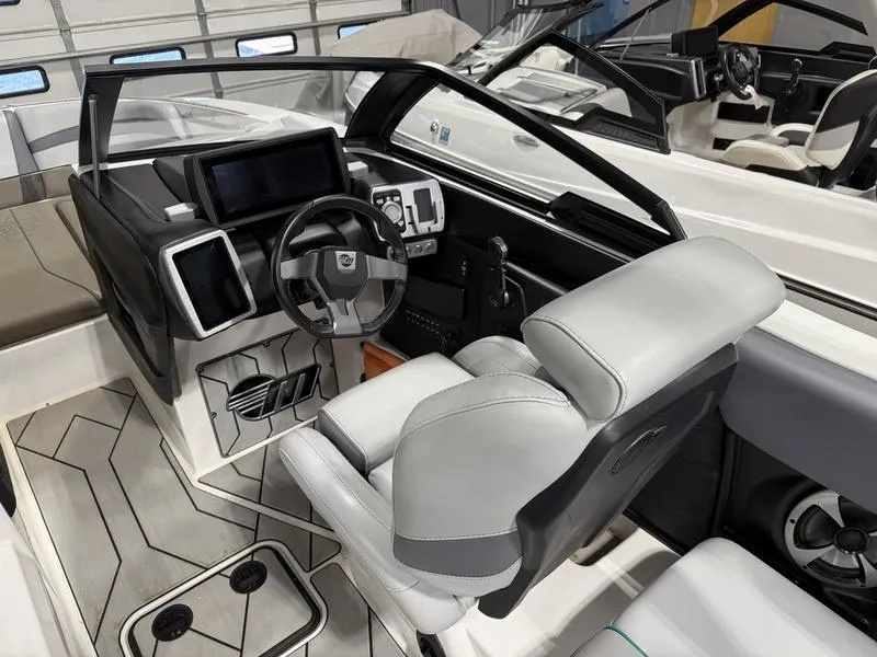 Slide: The Image of 2020 Malibu 24 MXZ boat interior with modern dashboard and comfortable seating. - 10