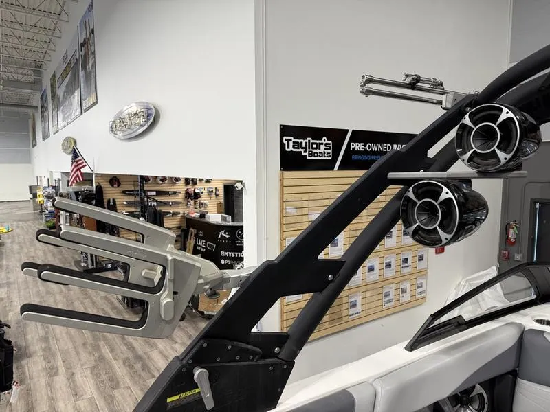 Slide: The Image of 2020 Malibu 24 MXZ boat interior with speakers and wakeboard rack in showroom. - 13