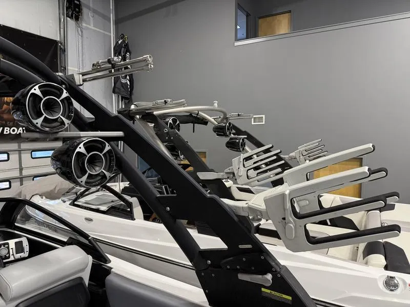 Slide: The Image of 2020 Malibu 24 MXZ boat with wakeboard racks and speakers in a garage. - 14