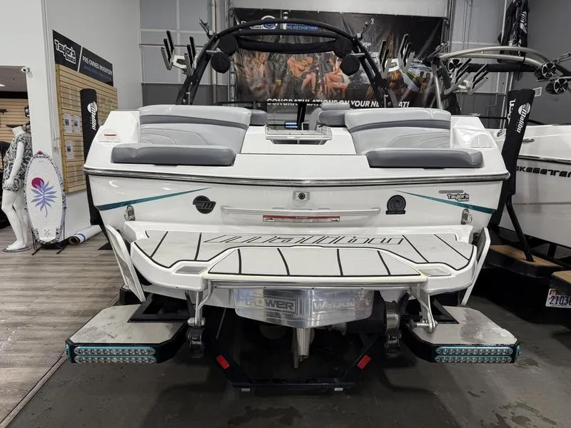 Slide: The Image of 2020 Malibu 24 MXZ boat, rear view in showroom, showcasing swim platform and seating. - 3