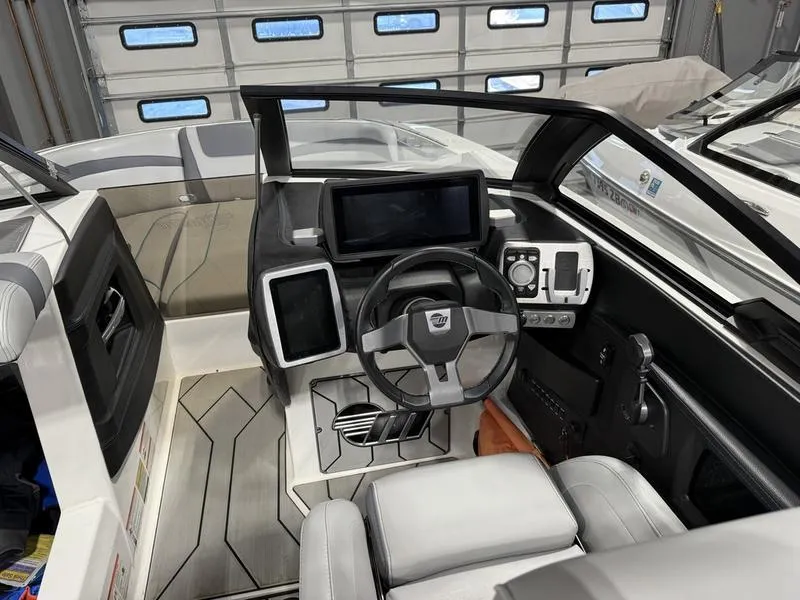 Slide: The Image of 2020 Malibu 24 MXZ boat interior with modern dashboard and steering wheel. - 9