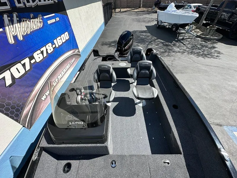 Slide: The Image of 2025 Lund 1650 Rebel XL SS fishing boat with seating and motor, parked outdoors. - 10
