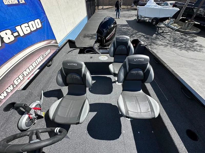Slide: The Image of 2025 Lund 1650 Rebel XL SS boat interior with four seats and motor. - 12