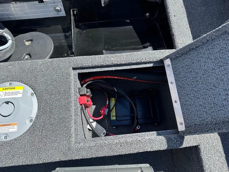 Slide: The Image of 2025 Lund 1650 Rebel XL SS boat battery compartment with wiring and storage. - 14
