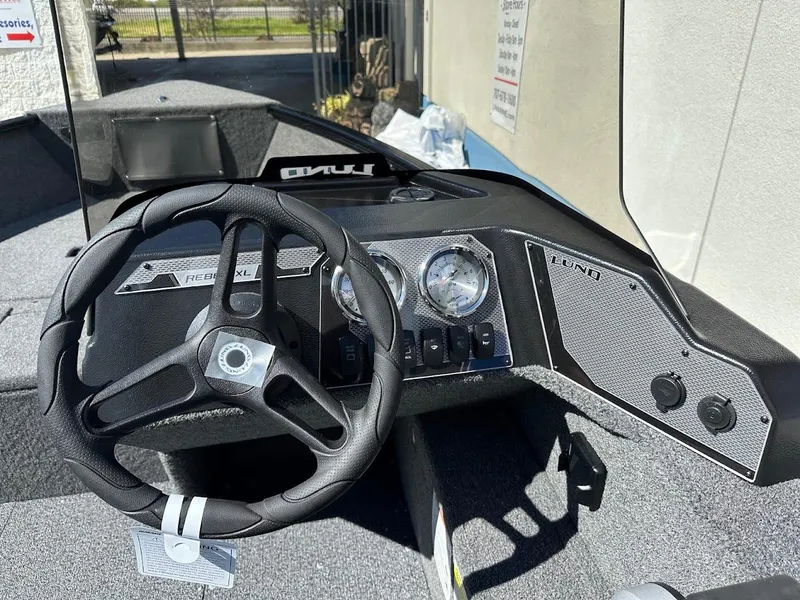 Slide: The Image of 2025 Lund 1650 Rebel XL SS boat dashboard with steering wheel and gauges. - 18