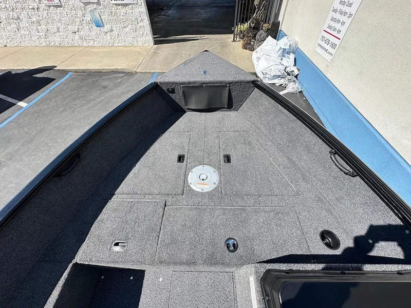 Slide: The Image of 2025 Lund 1650 Rebel XL SS boat interior with gray carpeted deck. - 20