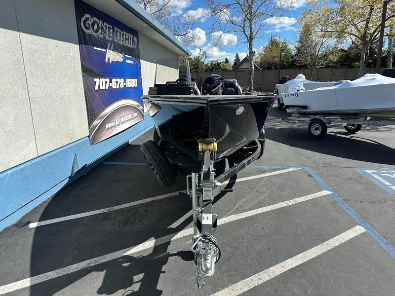 Slide: The Image of 2025 Lund 1650 Rebel XL SS boat on trailer in parking lot, sunny day. - 3