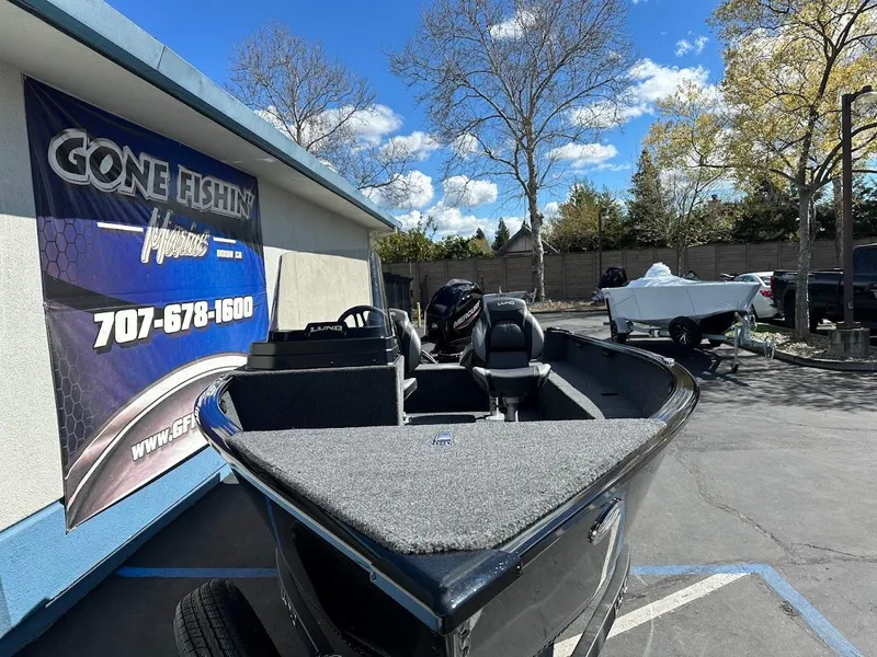 Slide: The Image of 2025 Lund 1650 Rebel XL SS boat displayed outdoors at a dealership. - 5