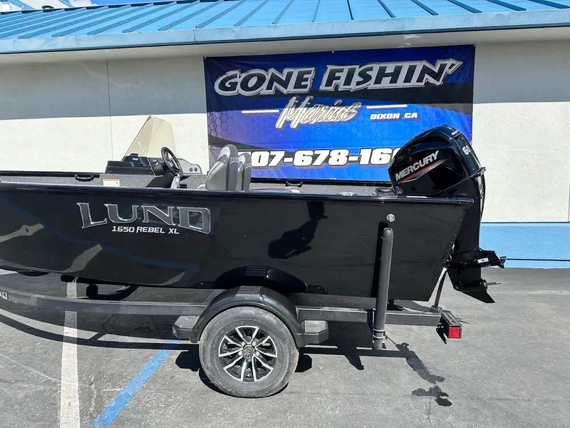 Slide: The Image of 2025 Lund 1650 Rebel XL SS boat with Mercury engine, parked at dealership. - 6