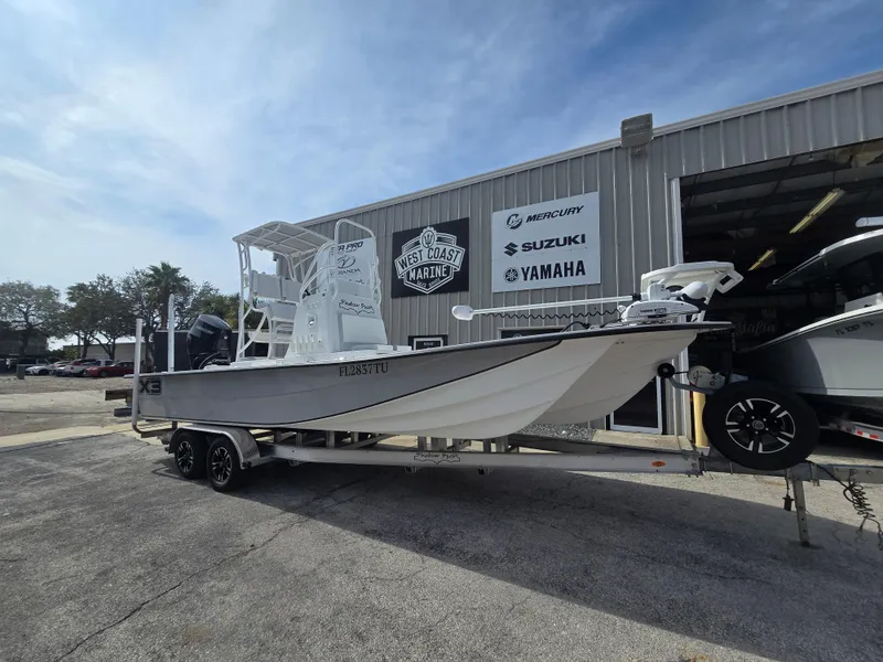 Slide: The Image of 2024 Shallow Sport X3 boat on trailer outside West Coast Marine dealership. - 1