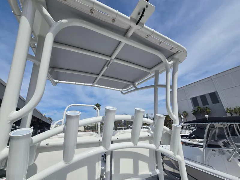 Slide: The Image of 2024 Shallow Sport X3 boat with rod holders and canopy under a clear sky. - 11