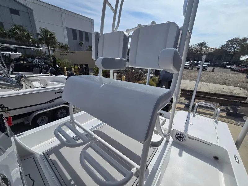 Slide: The Image of 2024 Shallow Sport X3 boat seating area with white cushioned seats and footrests. - 18
