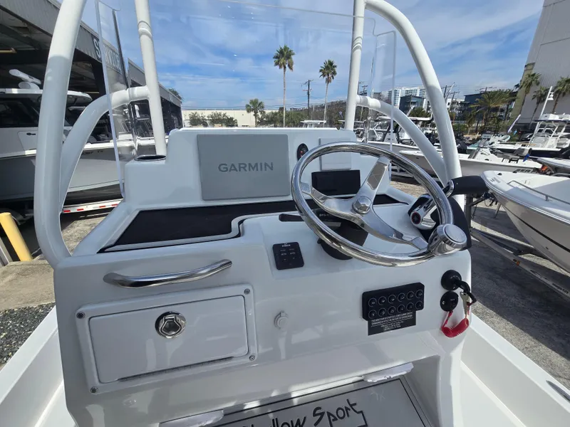 Slide: The Image of 2024 Shallow Sport X3 boat dashboard with Garmin navigation system and steering wheel. - 19