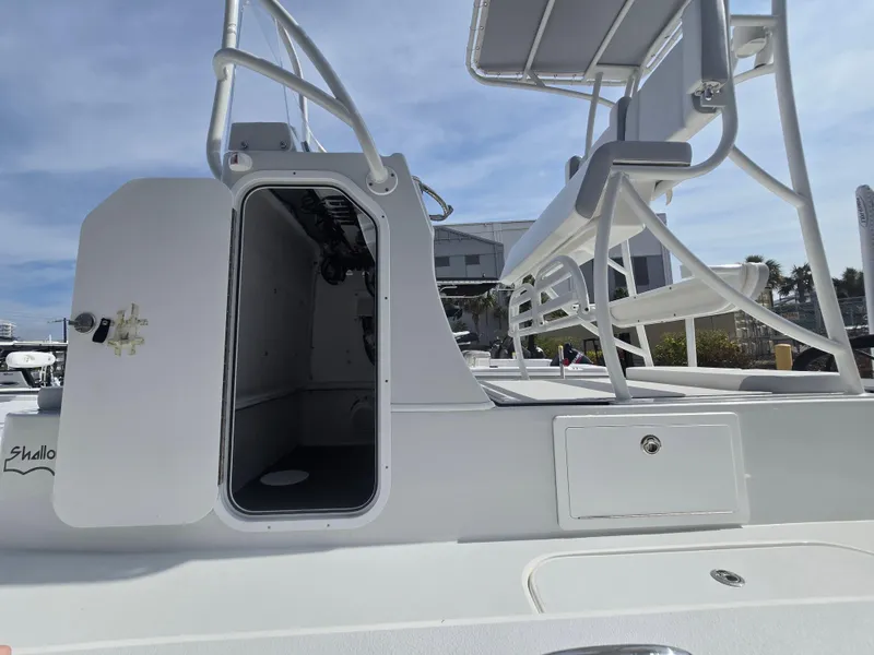 Slide: The Image of 2024 Shallow Sport X3 boat with open cabin and seating, docked under clear skies. - 21