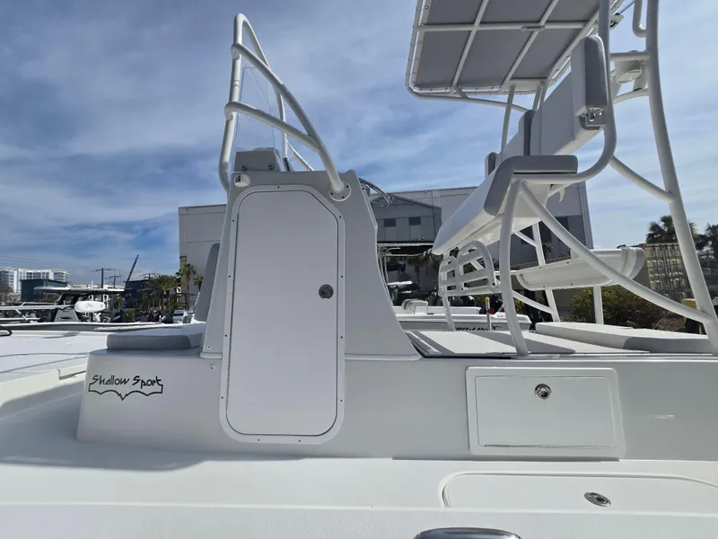 Slide: The Image of 2024 Shallow Sport X3 boat with elevated seating and storage compartments, docked under a clear sky. - 22