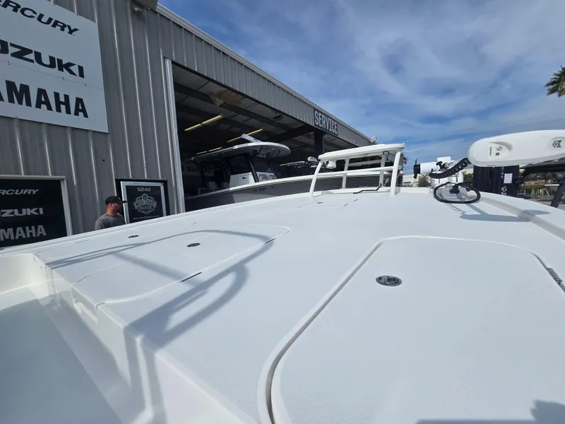 Slide: The Image of 2024 Shallow Sport X3 boat at dealership, showcasing deck and equipment under a clear sky. - 5