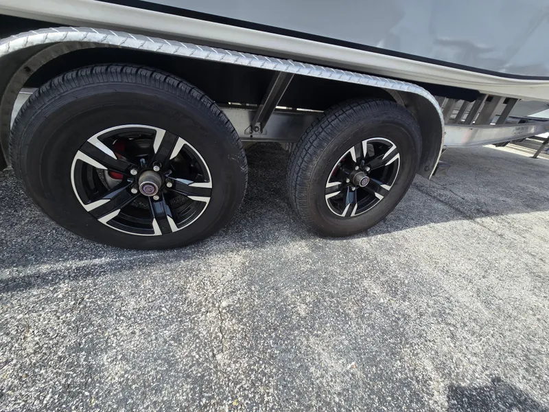 Slide: The Image of 2024 Shallow Sport X3 trailer wheels on asphalt surface. - 6