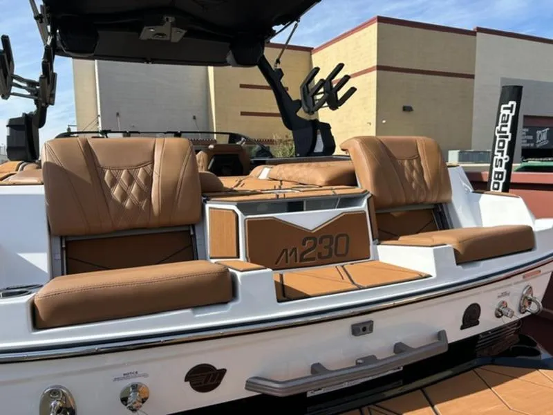 Slide: The Image of 2025 Malibu M230 boat with tan leather seats and sleek design. - 11