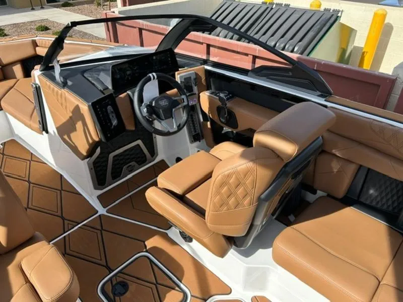 Slide: The Image of 2025 Malibu M230 boat interior with tan leather seats and modern dashboard design. - 12