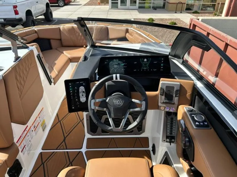 Slide: The Image of 2025 Malibu M230 boat interior with modern dashboard and tan seating. - 13