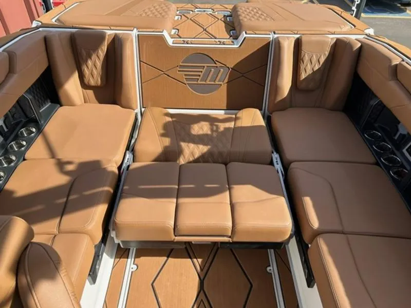 Slide: The Image of 2025 Malibu M230 boat interior with luxurious tan leather seating and stylish design. - 21