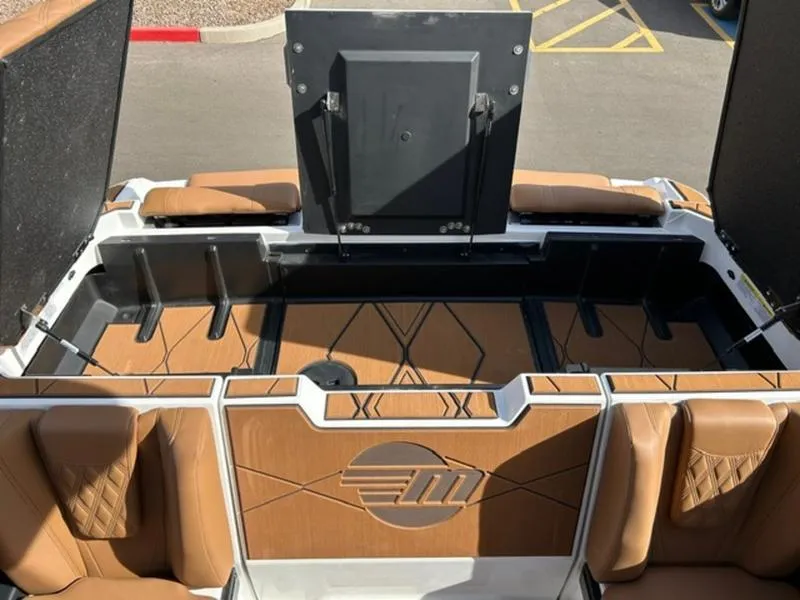 Slide: The Image of 2025 Malibu M230 boat interior with tan seating and storage compartments. - 24