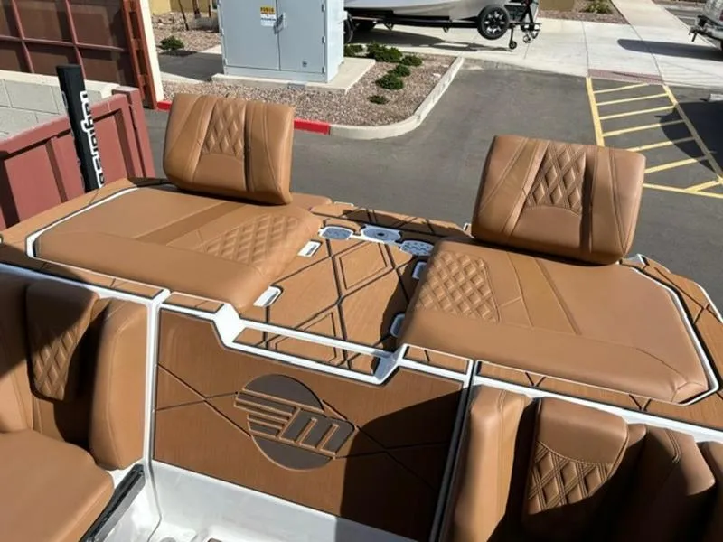 Slide: The Image of 2025 Malibu M230 boat interior with tan leather seats and stylish stitching. - 26