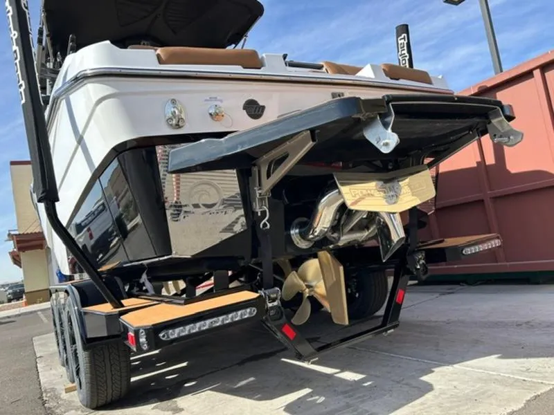 Slide: The Image of 2025 Malibu M230 boat on trailer, rear view showing propeller and hull design. - 6