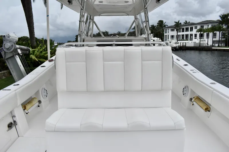Slide: The Image of 2013 Invincible 42 Open Fisherman boat with white seating, docked near waterfront homes. - 10