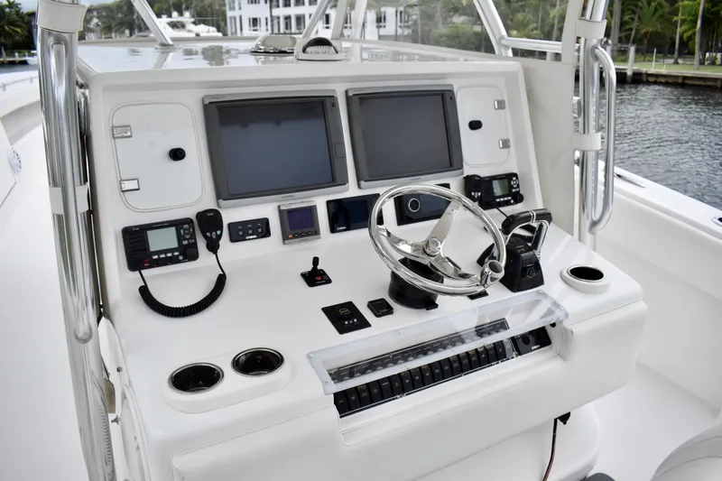 Slide: The Image of Control panel of 2013 Invincible 42 Open Fisherman boat with dual screens and steering wheel. - 11