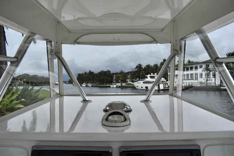 Slide: The Image of 2013 Invincible 42 Open Fisherman boat, view from helm, docked near waterfront homes. - 15