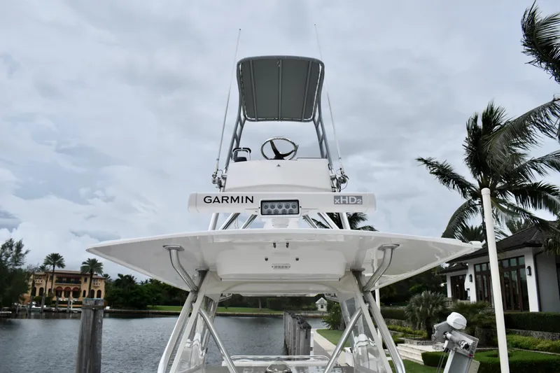 Slide: The Image of 2013 Invincible 42 Open Fisherman boat with Garmin equipment, docked near palm trees. - 21